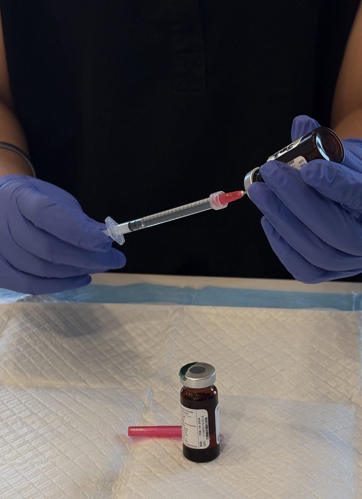 A clinical close-up of a Pure Drip nurse preparing an IV infusion
